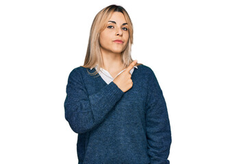 Young caucasian woman wearing casual clothes pointing with hand finger to the side showing advertisement, serious and calm face