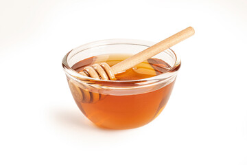 Honey in a glass jar with honey dipper isolated on white background.