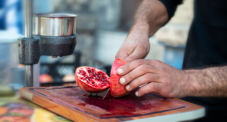 Man making pomegranate juice by hand with hand press juice maker. Street Food in Turkey.