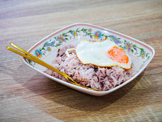 Thai fast food riceberry rice put the fried egg on top.
Thai breakfast fried egg with rice.
Rice toping eggs on dish are easy to make and have protein to keep the body healthy.