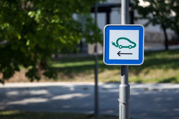 Selective blur on a road sign indicating an electric car charging station used to fill with electricity electrical vehicles, abiding by European laws on traffic signalization. ..