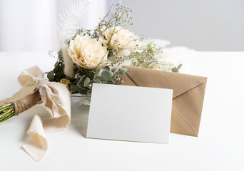 Dried flower bouquet and blank message card placed on white background.