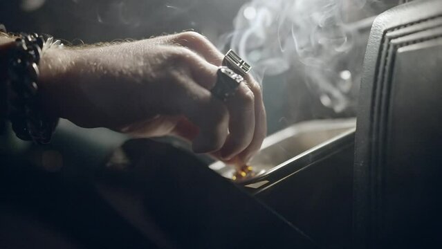 Close-Up Lockdown Of A Hand As It Puts Out A Cigarette In The Ashtray Of A Car - Erfurt, Germany