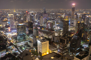 Aerial view of Ploenchit junction with cars traffic skyscraper buildings. Bangkok City in downtown at night, Thailand