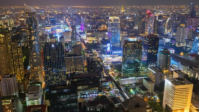 Aerial view of Ploenchit junction with cars traffic skyscraper buildings. Bangkok City in downtown at night, Thailand
