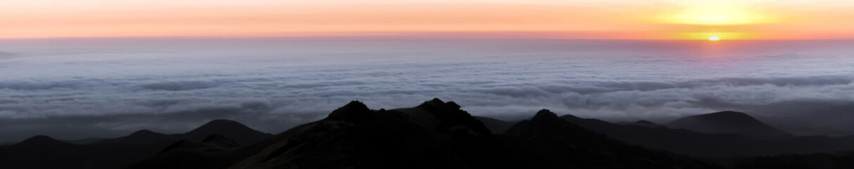 Fototapeta na wymiar Sun Setting Above the Clouds via CA State Route 35 in Santa Cruz Mountains, California, USA.