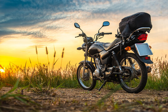 Black Retro Motorcycle With Backpack Parked Outdoors.