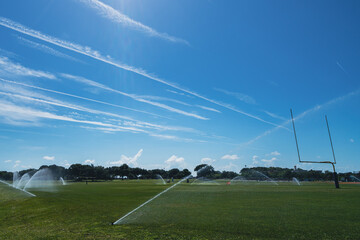 Irrigation sprinklers on a football field in a park in Florida