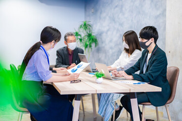 マスクをして会議をするビジネスパーソン