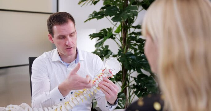 chiropractor explains the vertebrae in the spine to the patient