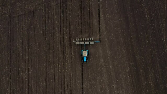 Tractor with Plough on Plowed. Ploughing and Soil Tillage. Agricultural Tractor on Cultivation Field for Sowing Seeds. Tractor During Field Cultivating. Planting and Seeding Equipment.