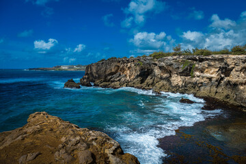 2022-05-03 WAVES COMING UP ON THE SHORE NEAR THE PILI MAI RESORT WITH BLUE WATER AND NICE SKY AND CLOUDS ON KAUAI HAWAII