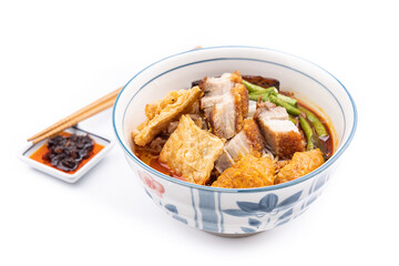 Curry mee or curry laksa is noodle served in curry broth made of cocunut milk, accompanied with roast pork, bean curd, vegetables.