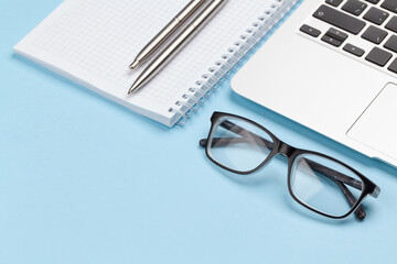 Fototapeta premium Office desk with supplies, glasses and laptop