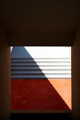 白色とオレンジ色の階段に斜めにできた影