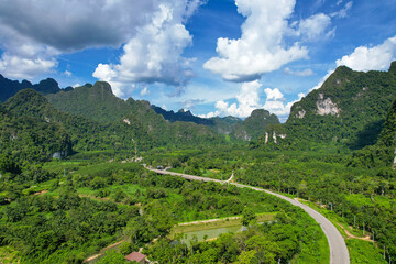 aerial view of mountains greenery nature Against the beautiful sky along the roadway that leads to the destination on the hill.