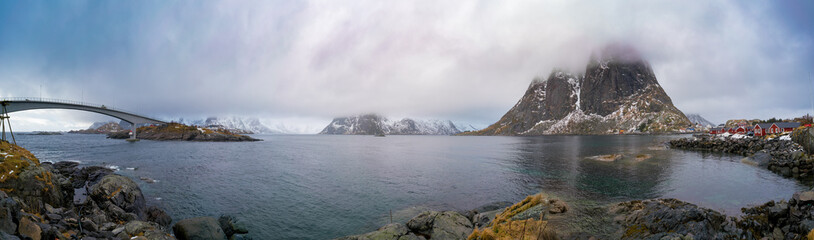 Norwegian fjords in spring and mountains at low clouds panorama