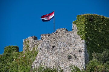 Medieval fortress on the top of  the hill with flag waving on a pole
