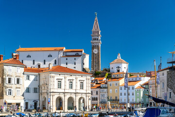 Naklejka premium Beautiful city of Piran with Tartini Square, Monument of Giuseppe Tartini and St. George Church on a warm, sunny eastertime day against deep blue sky. Popular tourist attraction of Slovenia 