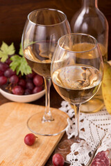 Wine and grapes in vintage setting on wooden table.