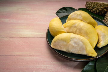 Fresh Durian fruit on black plate, Durian fruit with peel the King of fruits on wooden background.