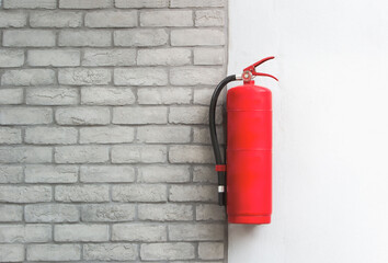 Fire extinguisher  on white brick wall background.