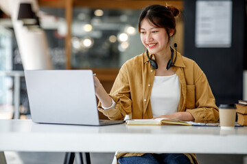 Young adult happy smiling Hispanic Asian student wearing headphones talking on online chat meeting...