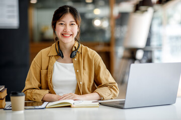 Young adult happy smiling Hispanic Asian student wearing headphones talking on online chat meeting...