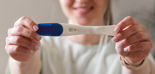 the woman found out about the long-awaited pregnancy. A girl with a pregnancy test in her hands, the focus is on the pregnancy test