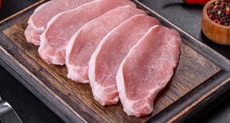 Raw fresh pork meat sliced on a wooden cutting board