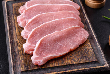Raw fresh pork meat sliced on a wooden cutting board