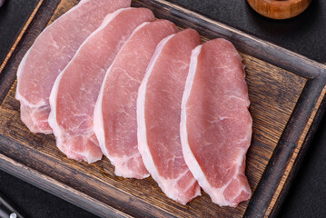 Raw fresh pork meat sliced on a wooden cutting board