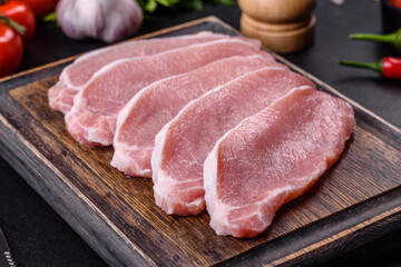Raw fresh pork meat sliced on a wooden cutting board