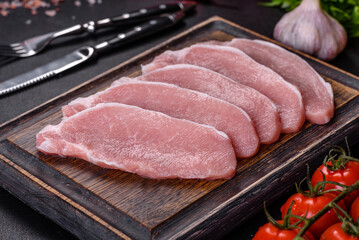 Raw fresh pork meat sliced on a wooden cutting board