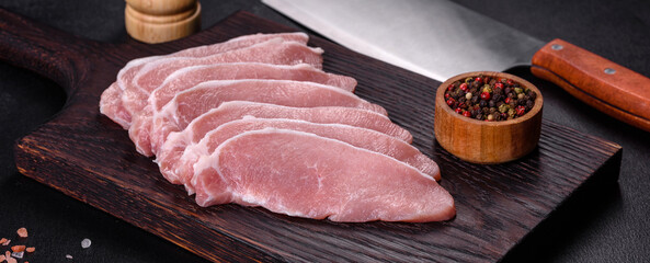 Raw fresh pork meat sliced on a wooden cutting board