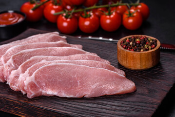 Raw fresh pork meat sliced on a wooden cutting board