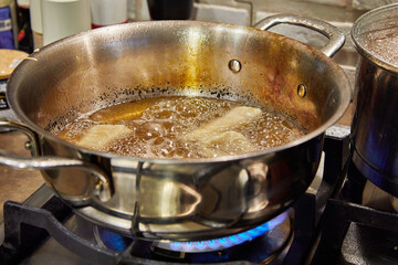 Bugnes, French donuts in boiling oil in saucepan