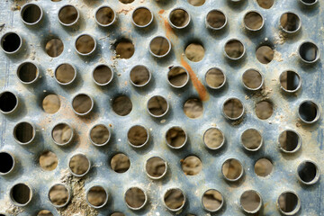Close up of cement encrusted metal scaffolding planks
