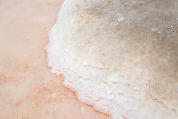 Pink salt pan up close with salt crystals out of focus with grain