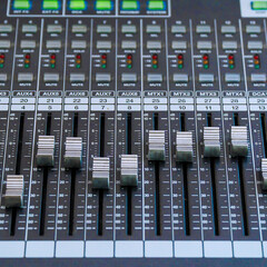 Faders and control buttons on the mixing console. Selective focus