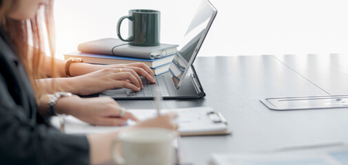 Two young businesswoman working on computer at office.