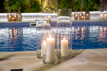 Blue pool with copper lanterns at night candles with grain and out of focus