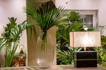 interior with glass vase palm tree leaves and light out of focus with grain