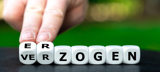 Hand turns dice and changes the German word 