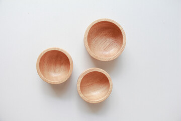 Wooden small bowl and white fabric background for cosmetic products. top view, copy space.