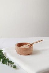 Wooden small bowl and white fabric background for cosmetic products. 