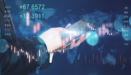 Global investing trading concept with businessman hand using digital tablet and virtual interface screen with forex chart indicators, candlesticks, and world map.