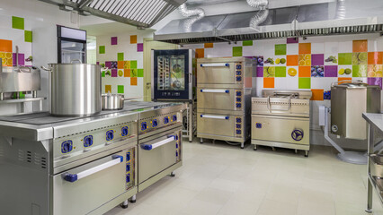 Interior of a room for cooking in a kindergarten. Close-up, new dishes and household equipment.