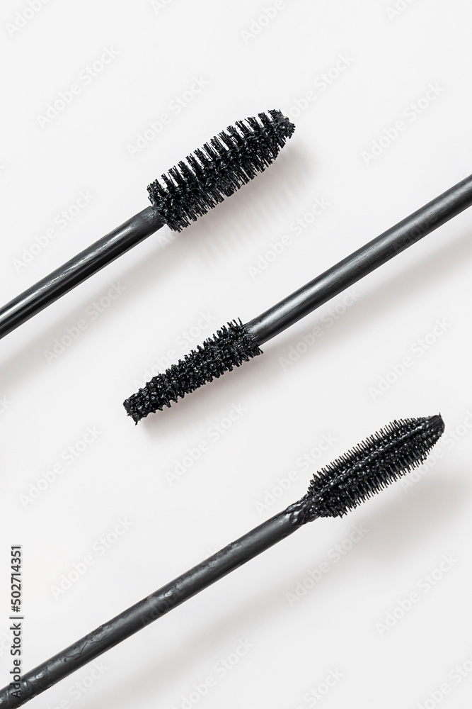 Wall mural three black mascara brush applicators close-up, isolated on white background. beauty product.