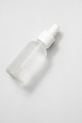 Glass matte bottle cosmetic droper on neutral background. Skin care oils, vitamins, collagen. Packaging of cosmetic beauty product, pack shot, copy space